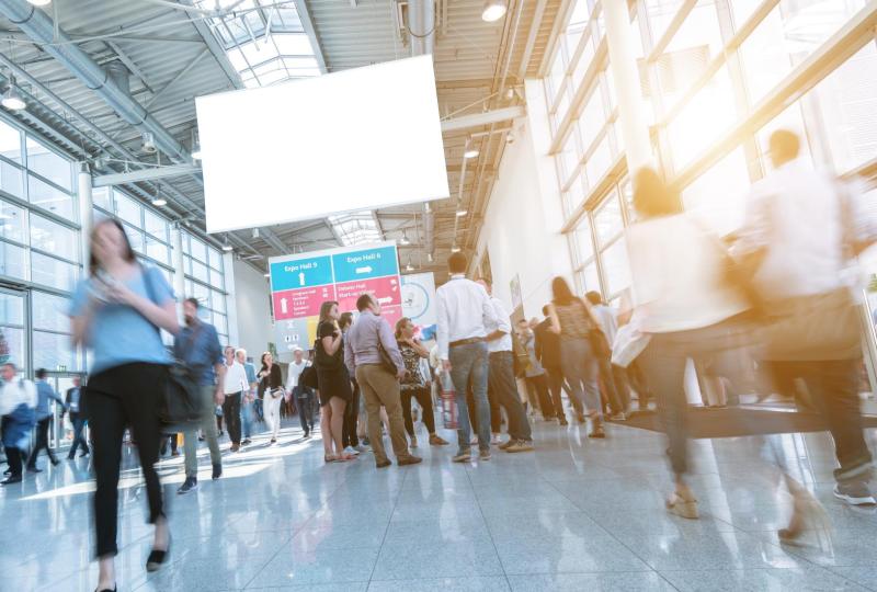 Folla vivace in una fiera, movimento e connessioni in un ambiente luminoso.