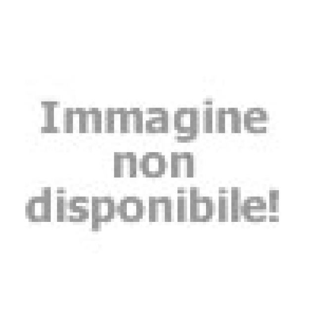 Due donne sorridenti brindano in bikini, atmosfera estiva e rilassata.